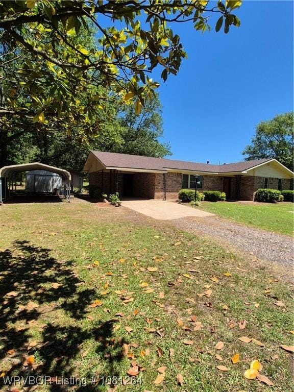 1382 6th St, Waldron, AR 72958 - view of front of property with driveway, a front lawn, a detached carport, and brick siding