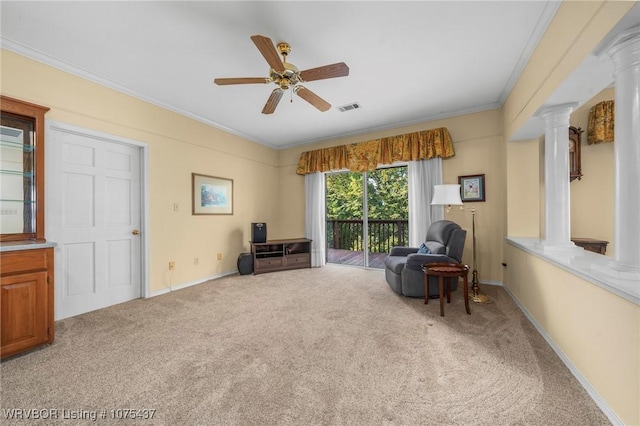 living area featuring decorative columns, light carpet, crown molding, and ceiling fan