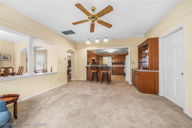 kitchen with crown molding, ceiling fan, and light colored carpet