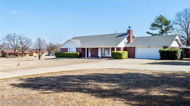 ranch-style home with a garage, driveway, and a chimney