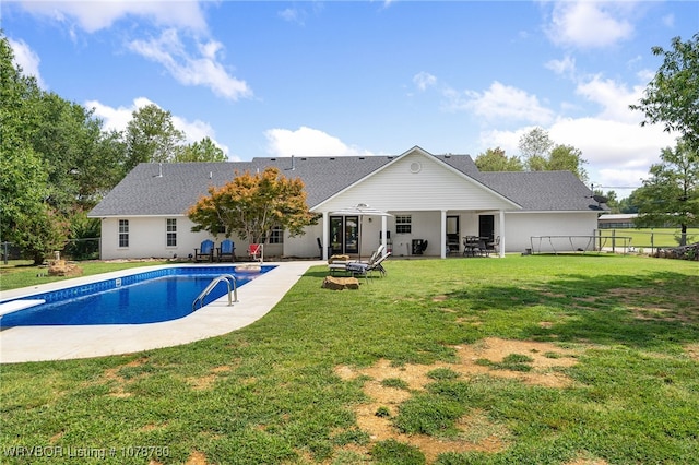 rear view of property with a yard and a patio area