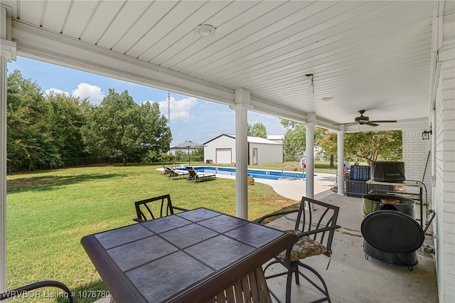 view of patio with an outdoor structure and ceiling fan