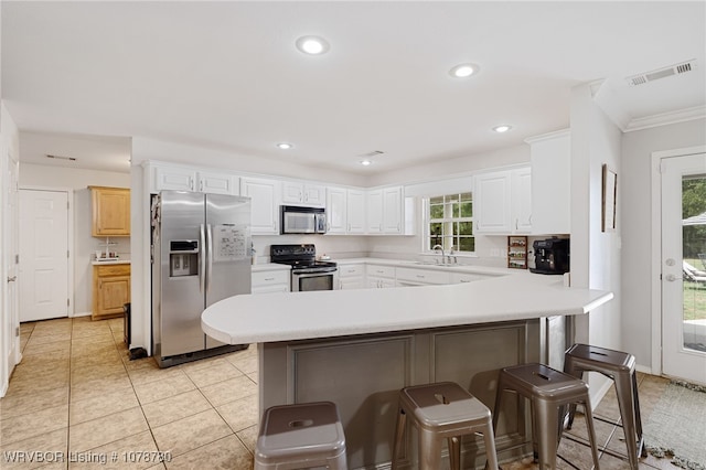 kitchen with white cabinetry, sink, a kitchen breakfast bar, kitchen peninsula, and stainless steel appliances