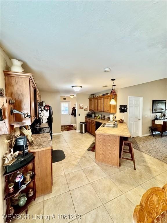 195 Polk 492, Cove, AR 71937 - kitchen featuring a breakfast bar area, light tile patterned floors, a peninsula, a sink, and light countertops