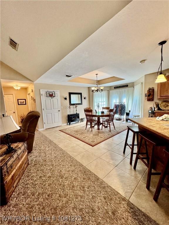 195 Polk 492, Cove, AR 71937 - dining room featuring light tile patterned floors, a chandelier, and a raised ceiling