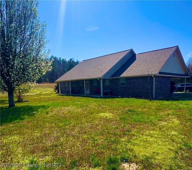 195 Polk 492, Cove, AR 71937 - view of home's exterior featuring a yard, roof with shingles, and brick siding