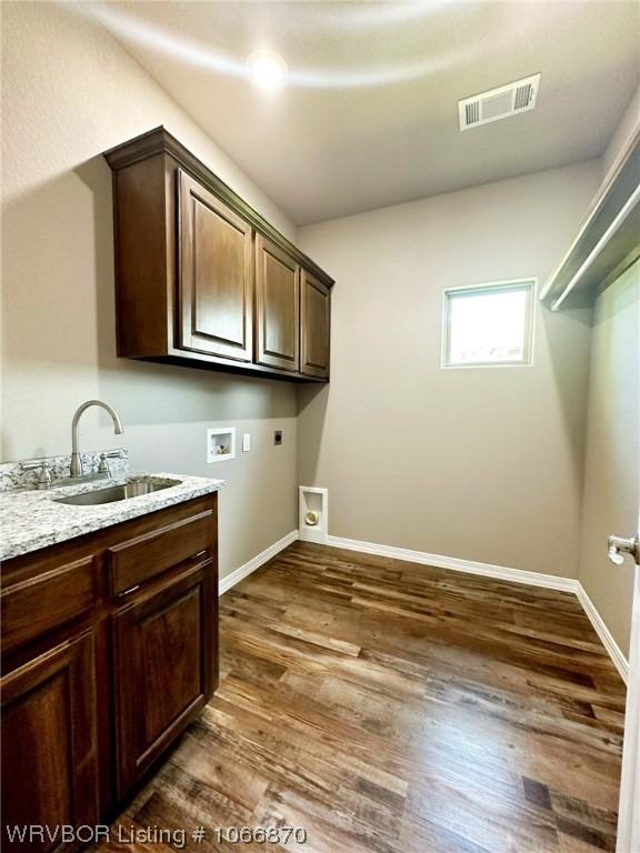 washroom with hookup for an electric dryer, washer hookup, dark hardwood / wood-style flooring, cabinets, and sink