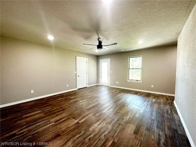 unfurnished room with ceiling fan, dark wood-type flooring, and a textured ceiling