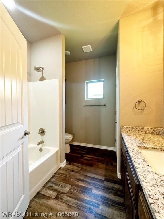 full bathroom with toilet, vanity, wood-type flooring, and washtub / shower combination