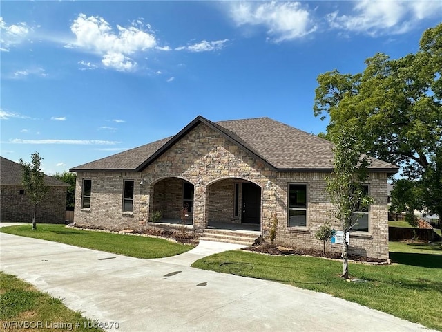 french country inspired facade with covered porch and a front yard