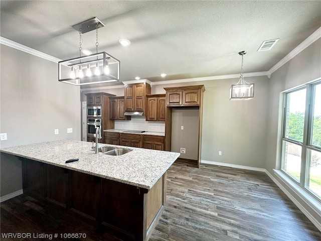 kitchen featuring light stone countertops, sink, stainless steel appliances, tasteful backsplash, and pendant lighting