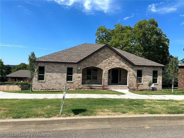 view of front of house with covered porch and a front lawn