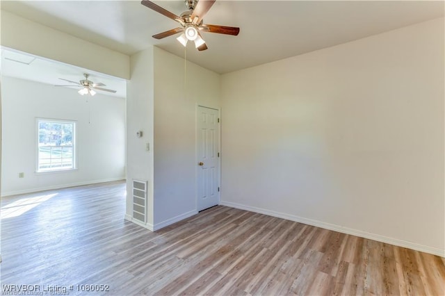 empty room with baseboards, a ceiling fan, and light wood finished floors