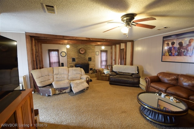 carpeted living room featuring ceiling fan, ornamental molding, a brick fireplace, and a textured ceiling