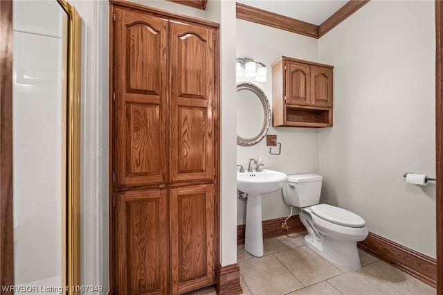 bathroom featuring tile patterned flooring, toilet, ornamental molding, and sink