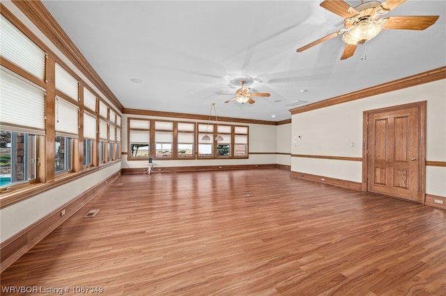 empty room with a healthy amount of sunlight, light wood-type flooring, ceiling fan, and ornamental molding