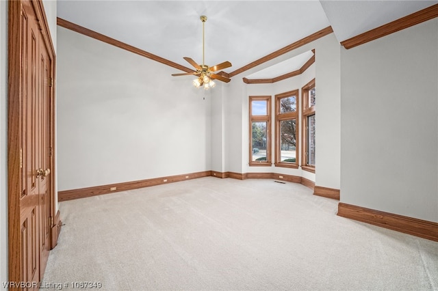 spare room featuring light carpet, ceiling fan, and ornamental molding