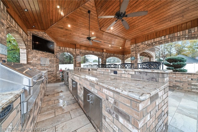 view of patio / terrace featuring ceiling fan, a grill, and exterior kitchen