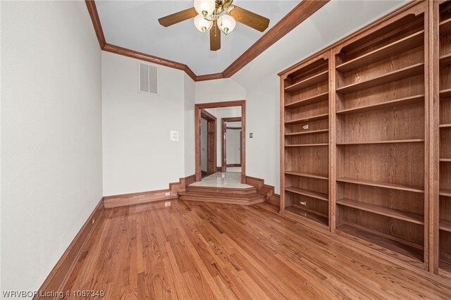 empty room featuring light hardwood / wood-style floors, vaulted ceiling, ceiling fan, and ornamental molding