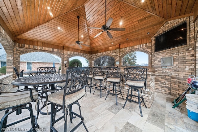 view of patio with ceiling fan and an outdoor bar