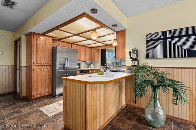 kitchen featuring appliances with stainless steel finishes, decorative light fixtures, kitchen peninsula, and a textured ceiling