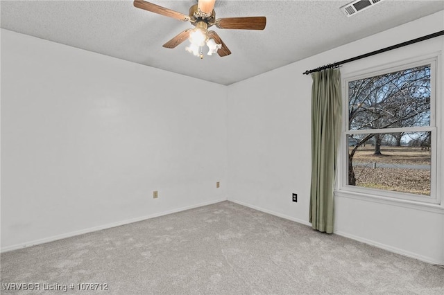 spare room featuring ceiling fan, light colored carpet, and a textured ceiling