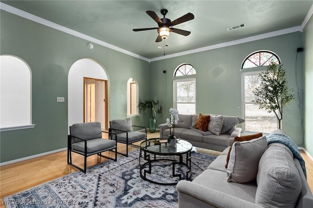 living room featuring ceiling fan, ornamental molding, and hardwood / wood-style floors