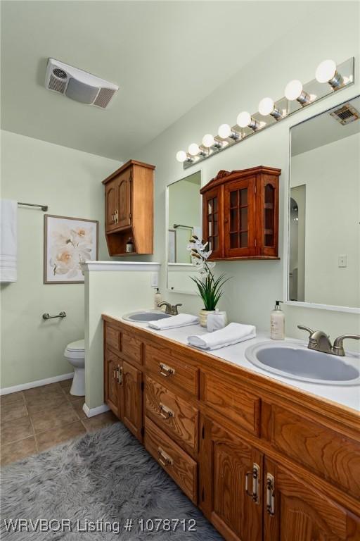 bathroom with vanity, tile patterned floors, and toilet