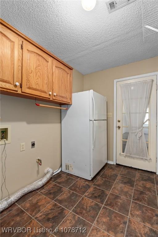 clothes washing area featuring cabinets, washer hookup, a textured ceiling, and electric dryer hookup