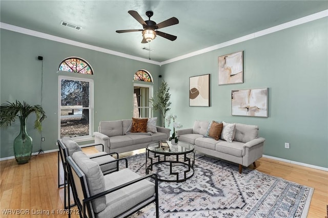 living room with hardwood / wood-style flooring, ornamental molding, and ceiling fan