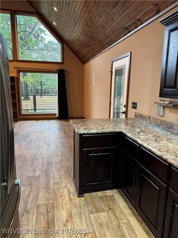185 Susie Ln, Mena, AR 71953 - kitchen with light stone countertops, light wood-type flooring, wood ceiling, and fridge