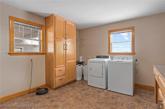 clothes washing area featuring cabinet space, independent washer and dryer, and baseboards