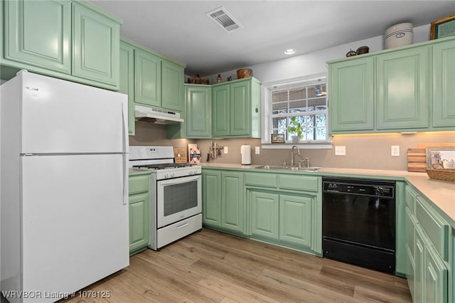 kitchen with light countertops, visible vents, a sink, white appliances, and under cabinet range hood