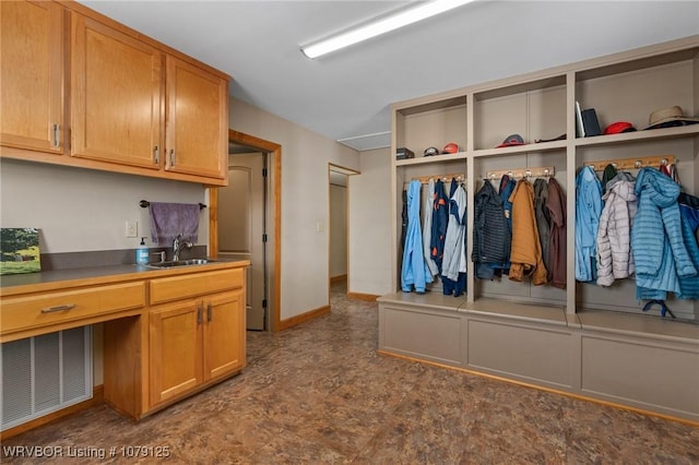 mudroom featuring baseboards, visible vents, a sink, and built in study area