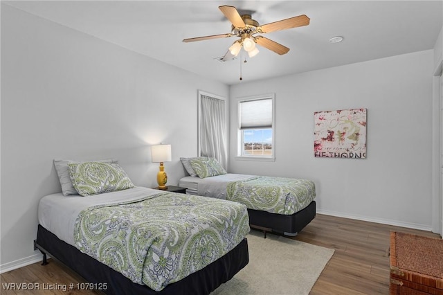 bedroom featuring ceiling fan, baseboards, and wood finished floors