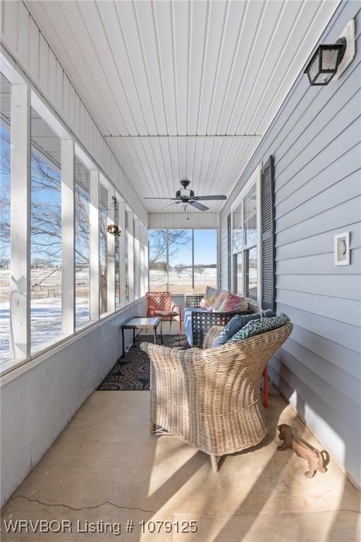 sunroom / solarium with a ceiling fan