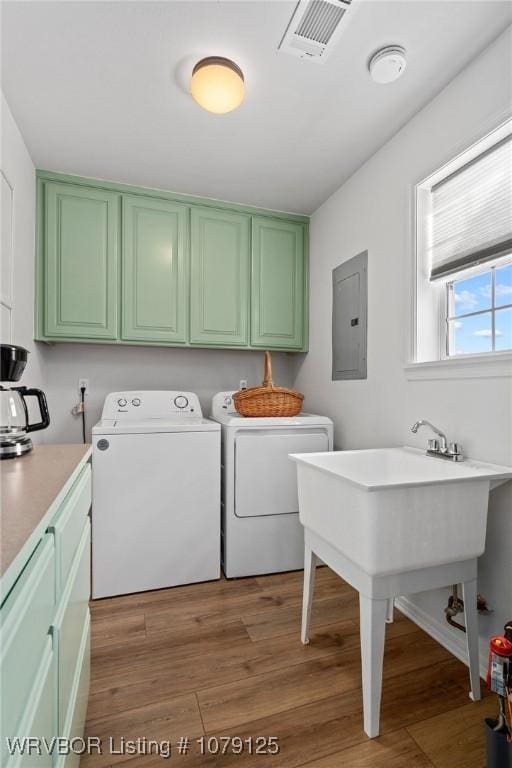 washroom featuring dark wood finished floors, cabinet space, visible vents, washer and dryer, and electric panel