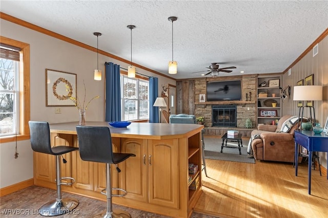 kitchen with pendant lighting, crown molding, and open floor plan