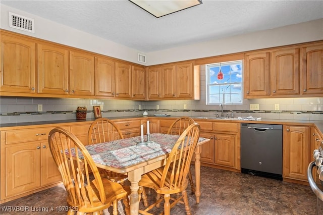 kitchen featuring dark countertops, visible vents, brown cabinetry, and dishwasher