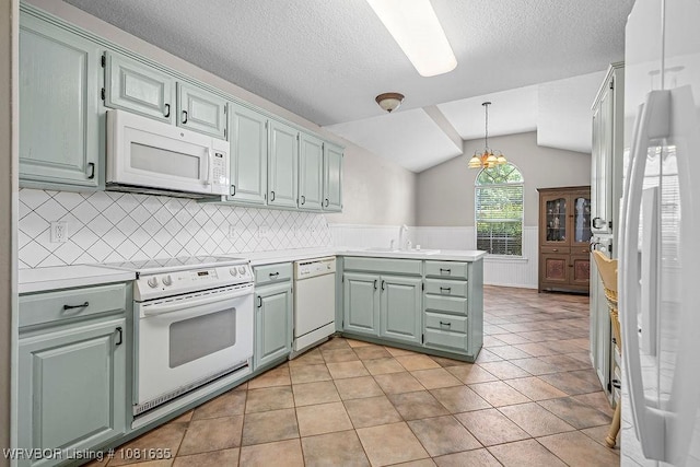 1129 Arapahoe Dr, Van Buren, AR 72956 - kitchen with white appliances, a peninsula, lofted ceiling, light countertops, and decorative backsplash