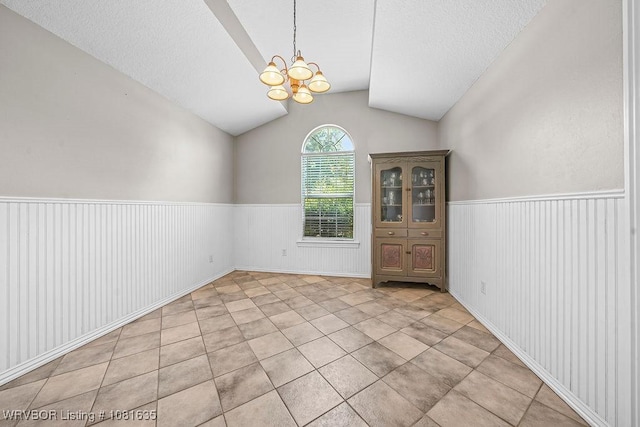 1129 Arapahoe Dr, Van Buren, AR 72956 - spare room featuring vaulted ceiling, wainscoting, a chandelier, a textured ceiling, and light tile patterned floors