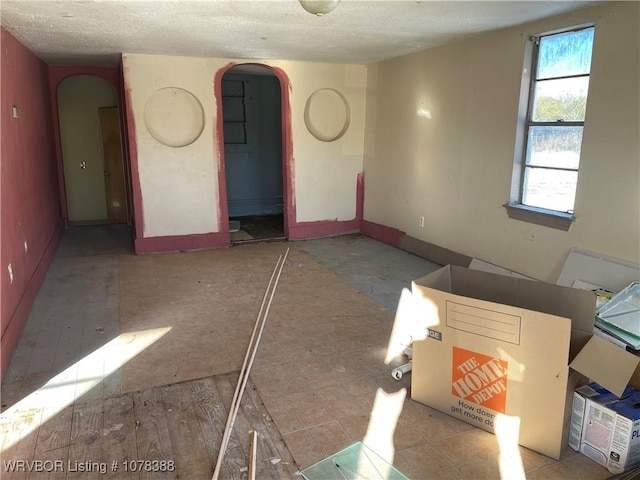 empty room featuring a textured ceiling and plenty of natural light