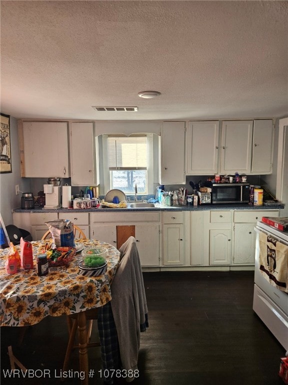 kitchen featuring white cabinets, a textured ceiling, and dark hardwood / wood-style floors