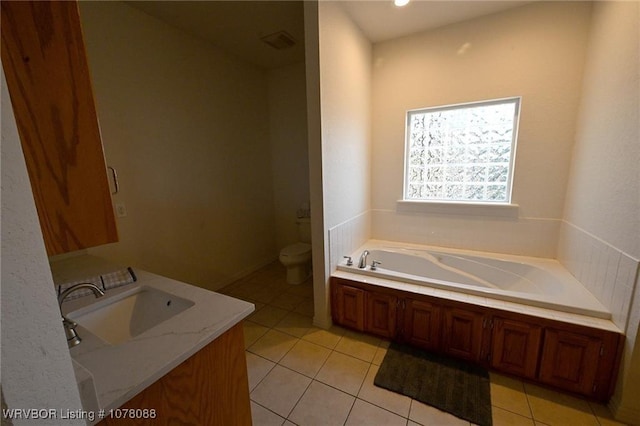 bathroom featuring a tub to relax in, tile patterned flooring, vanity, and toilet