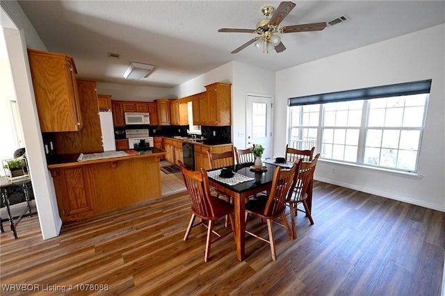 dining space with ceiling fan and dark hardwood / wood-style flooring