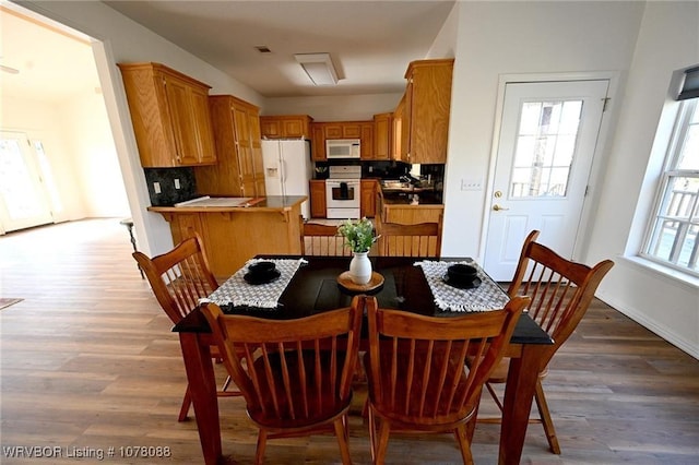 dining space with light hardwood / wood-style floors and plenty of natural light