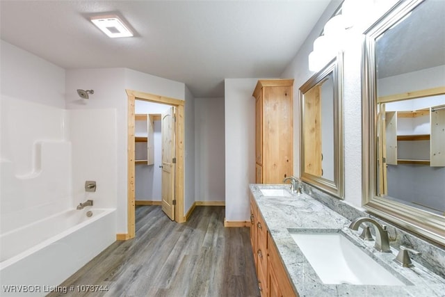 bathroom with hardwood / wood-style floors, vanity, and shower / bath combination