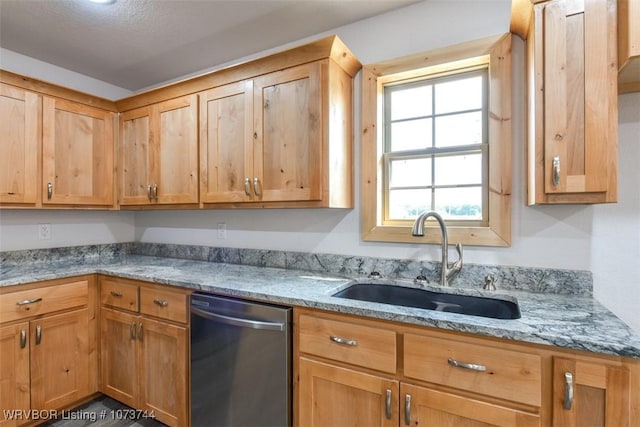 kitchen with light stone counters, stainless steel dishwasher, and sink