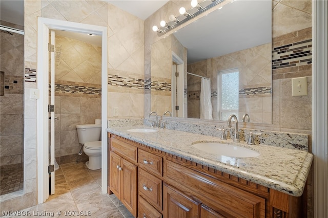 bathroom featuring a shower with shower curtain, vanity, toilet, and tile walls