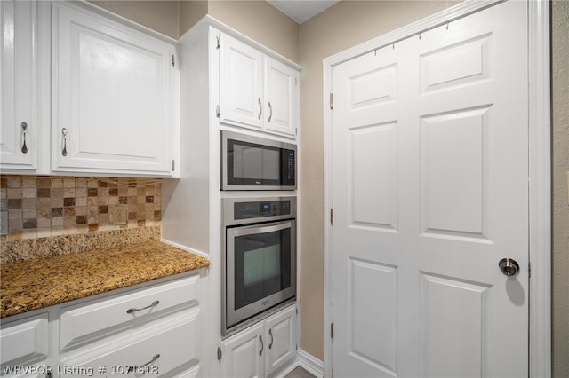 kitchen with backsplash, dark stone counters, oven, built in microwave, and white cabinetry